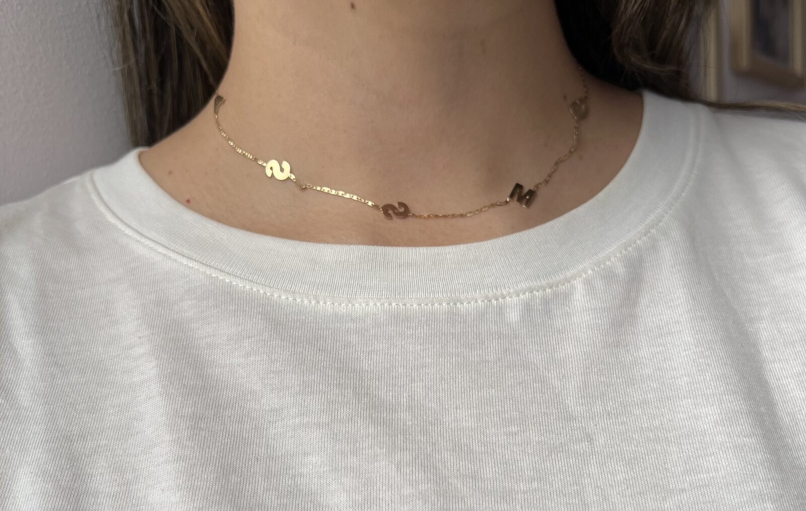 Detalle de letras de oro 18K en cadena delicada